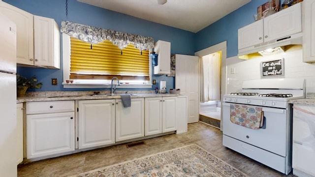 kitchen featuring white cabinets and white gas range