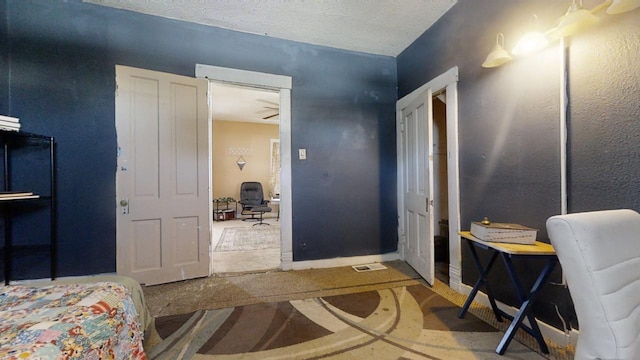 interior space with a textured ceiling and ceiling fan