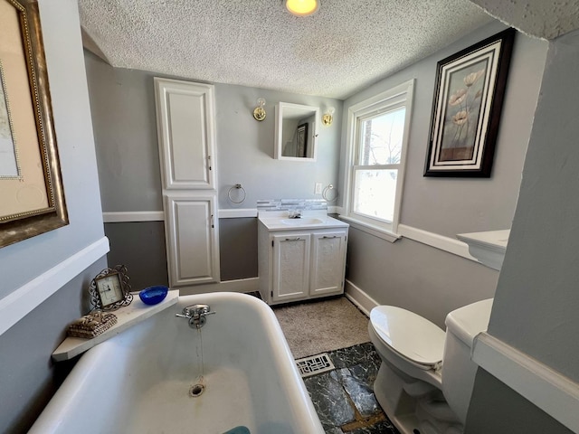 bathroom with toilet, a textured ceiling, a bathtub, and vanity