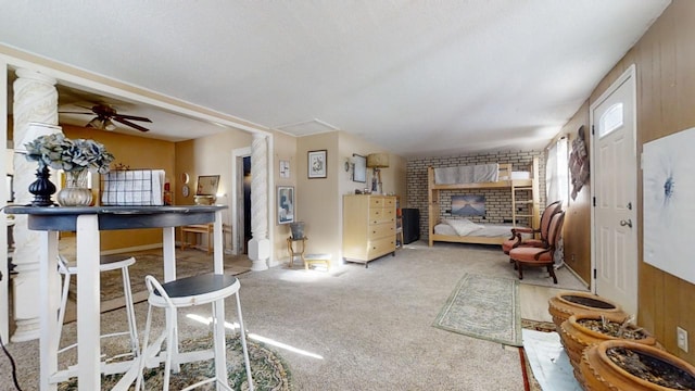 carpeted living room featuring a brick fireplace, ceiling fan, and wooden walls