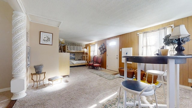 living room featuring a fireplace, a textured ceiling, wooden walls, and carpet