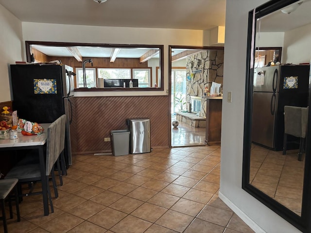 tiled dining room featuring beamed ceiling