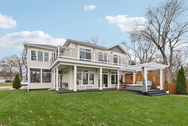 rear view of property with a pergola, a balcony, a sunroom, a patio, and a lawn