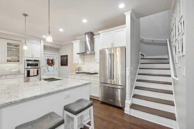 kitchen featuring white cabinetry, sink, wall chimney range hood, and stainless steel appliances