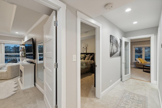 hall featuring light colored carpet and crown molding