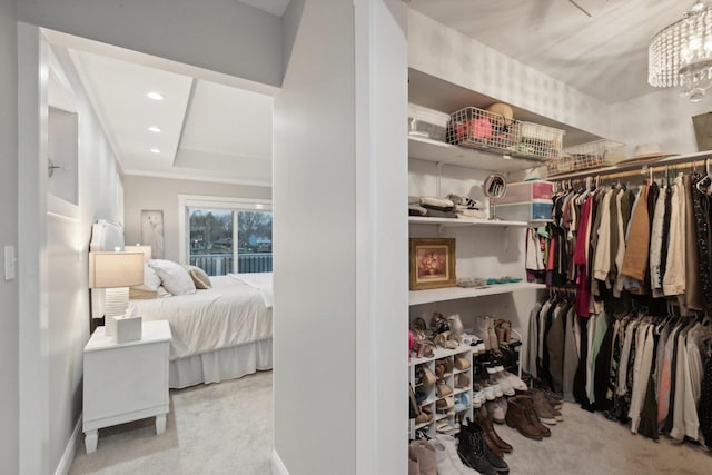 walk in closet with a raised ceiling and light colored carpet