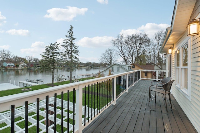 deck with a boat dock, a yard, and a water view