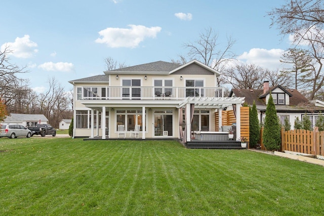 back of house with a pergola, a balcony, and a lawn