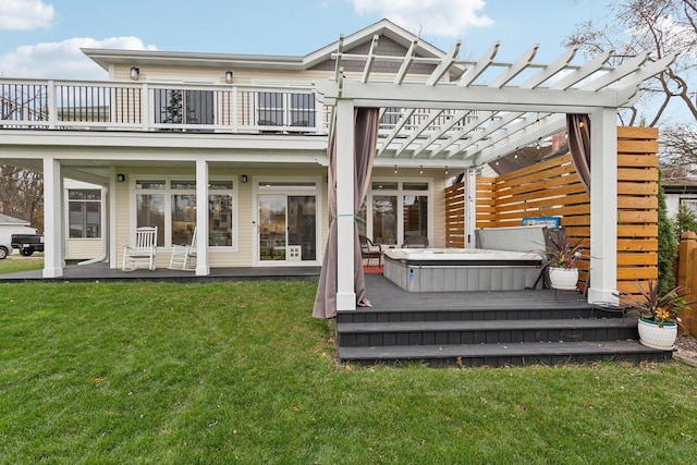 rear view of property with a yard, a pergola, a balcony, and a hot tub