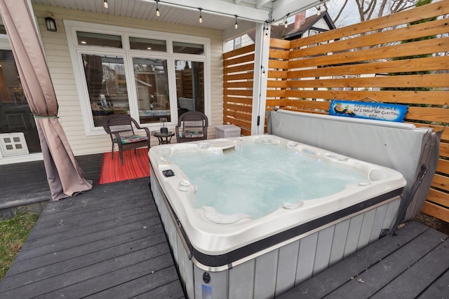 deck featuring a covered hot tub