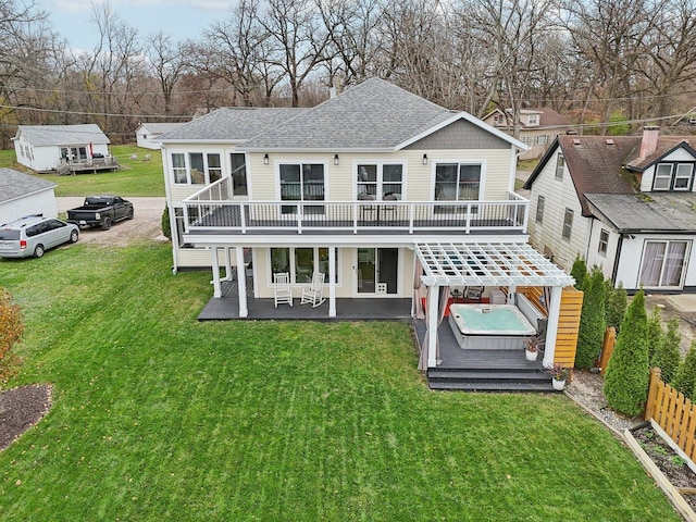 back of house featuring a patio area, a yard, a wooden deck, and a hot tub