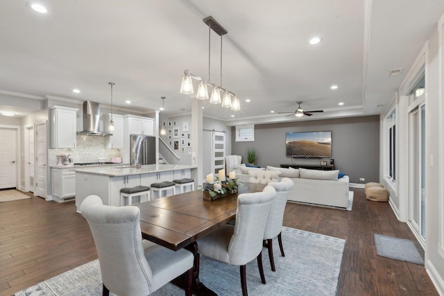 dining space with ceiling fan, dark hardwood / wood-style floors, and ornamental molding