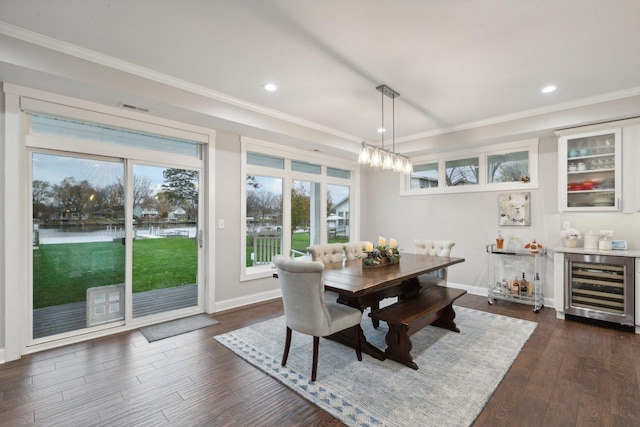 dining space with ornamental molding, beverage cooler, and dark wood-type flooring