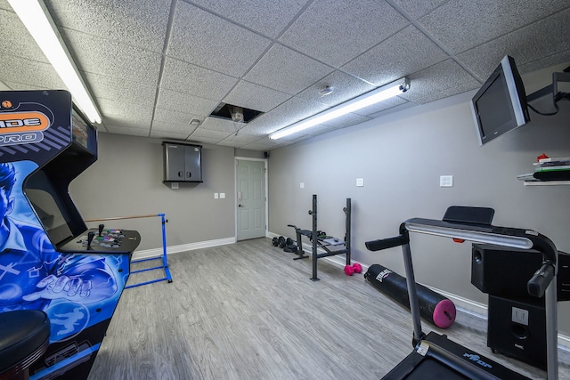 workout area featuring a drop ceiling and wood-type flooring