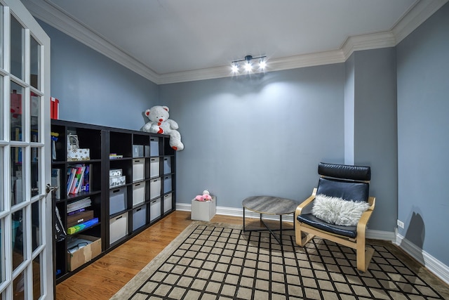 sitting room with ornamental molding and hardwood / wood-style flooring