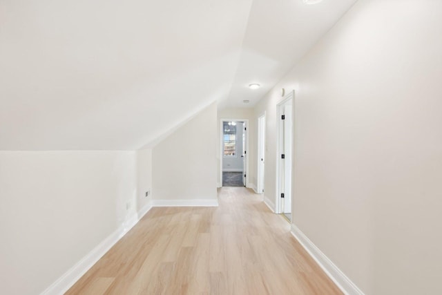 additional living space with light hardwood / wood-style flooring and vaulted ceiling