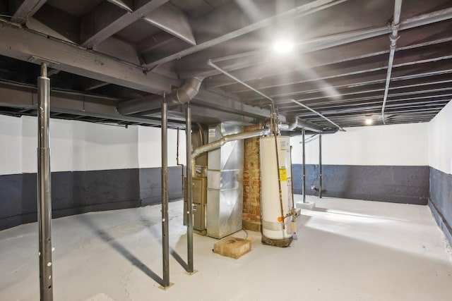 basement featuring gas water heater and heating unit