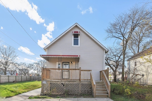 back of property featuring a lawn and a porch