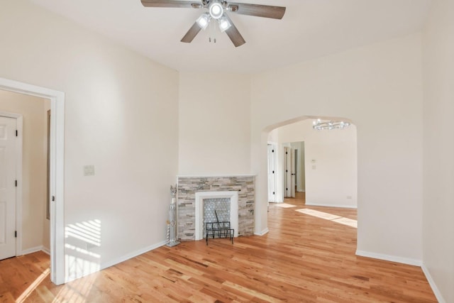 unfurnished living room with a fireplace, wood-type flooring, and ceiling fan