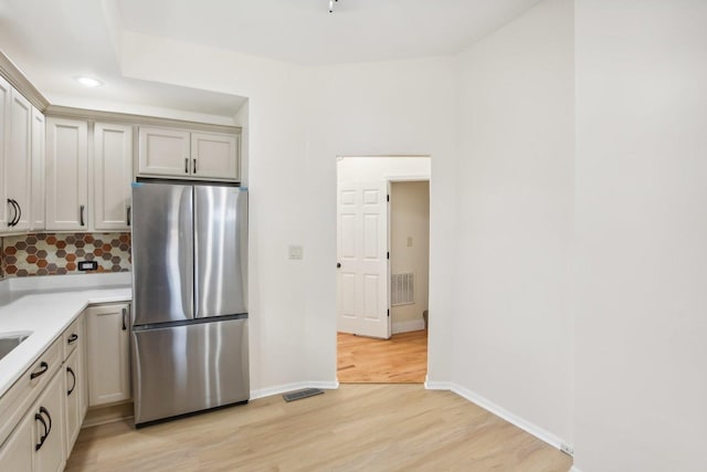 kitchen with stainless steel fridge and light hardwood / wood-style flooring