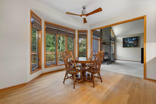 dining space with baseboards, a ceiling fan, and light wood-style flooring