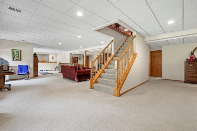 living area with baseboards, carpet flooring, stairs, and visible vents
