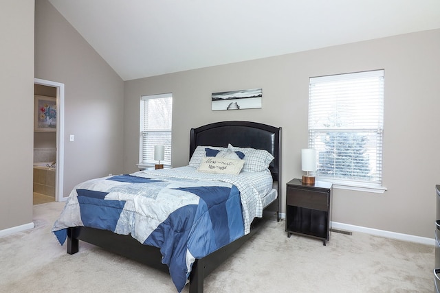 bedroom with light colored carpet, lofted ceiling, connected bathroom, and multiple windows