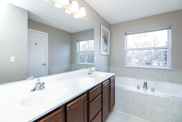 bathroom with vanity and tiled tub