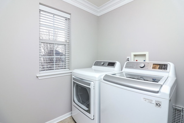 laundry room featuring light tile patterned flooring, independent washer and dryer, and crown molding