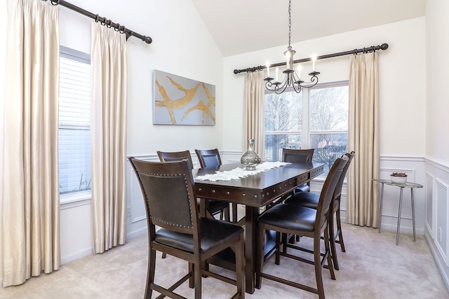 carpeted dining space with an inviting chandelier and vaulted ceiling