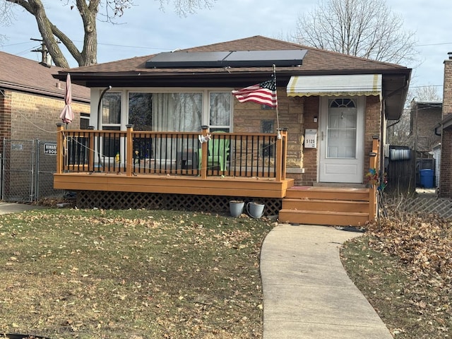 view of front of house featuring solar panels and a front lawn