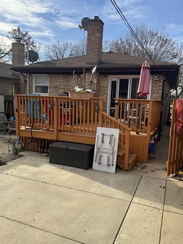 rear view of property with a wooden deck and a patio area