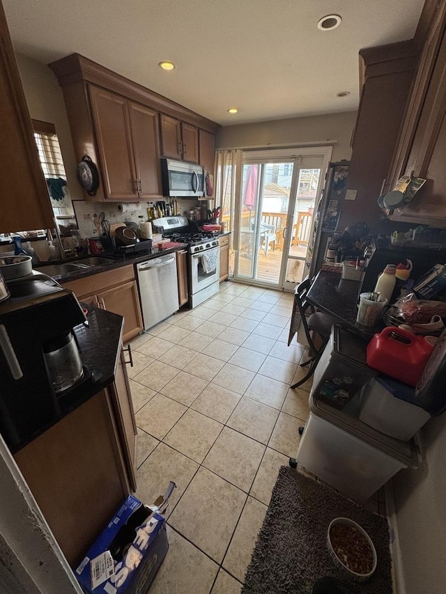 kitchen featuring appliances with stainless steel finishes, light tile patterned flooring, and sink