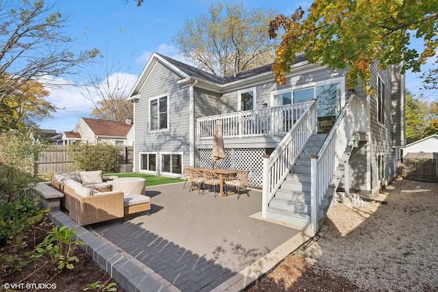 rear view of house with outdoor lounge area, a deck, and a patio area