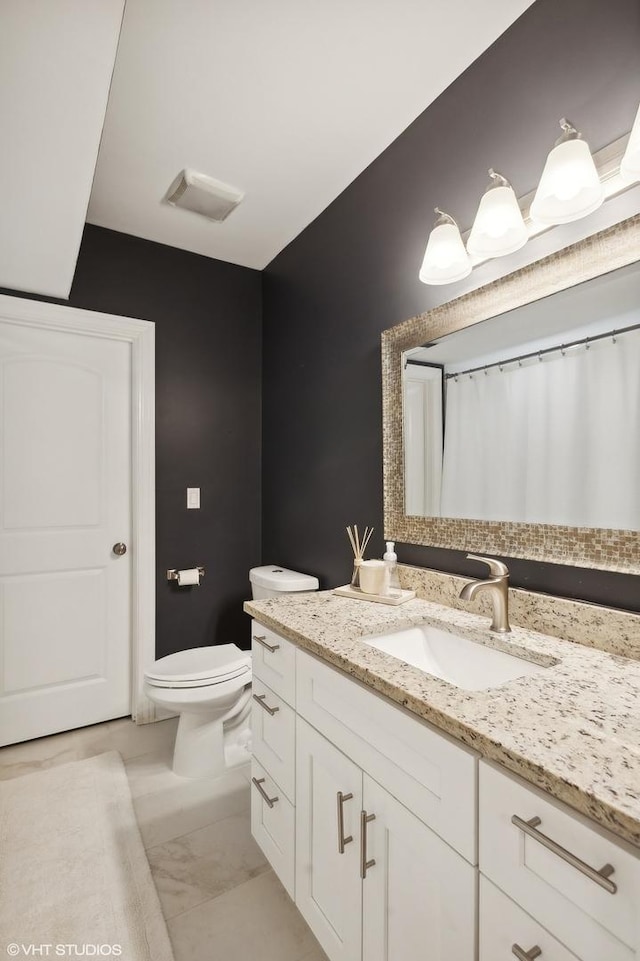 bathroom featuring vanity and toilet