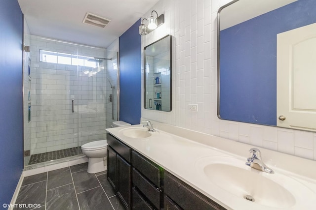 bathroom featuring tile patterned flooring, vanity, toilet, and a shower with door