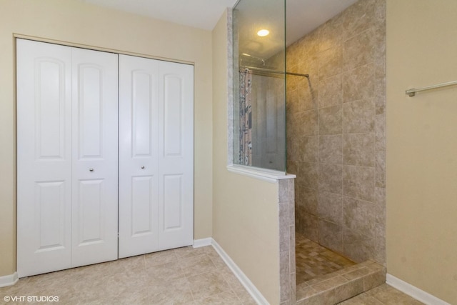 bathroom featuring tile patterned floors and a tile shower