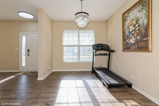 exercise area with a chandelier and wood-type flooring