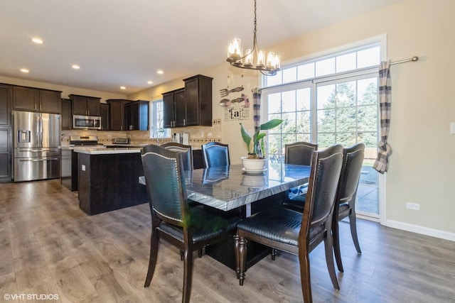 dining space featuring hardwood / wood-style flooring and a notable chandelier