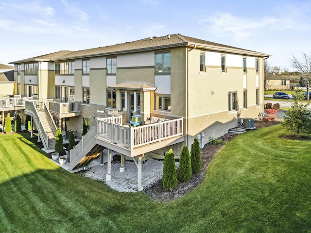 rear view of house with a lawn, cooling unit, and a deck