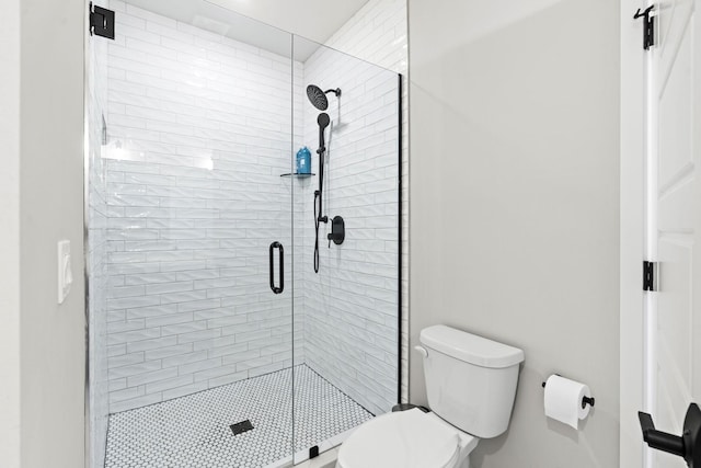 bathroom with toilet and a shower with shower door