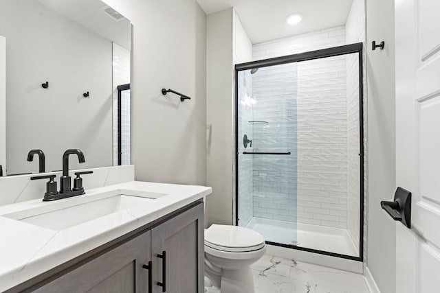 bathroom with a shower with door, vanity, and toilet