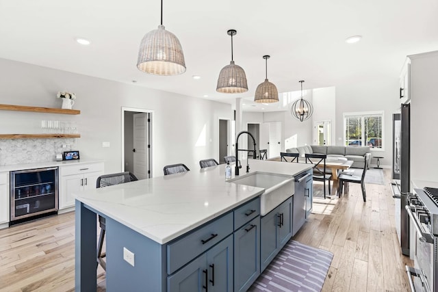 kitchen with a breakfast bar area, white cabinetry, and beverage cooler