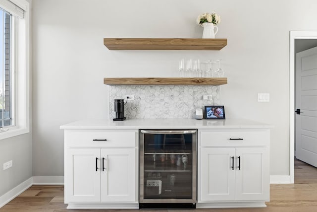 bar with white cabinets, plenty of natural light, and beverage cooler