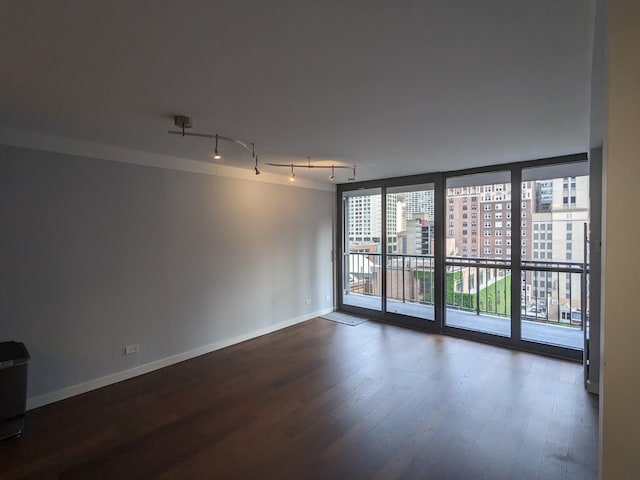 unfurnished room featuring dark hardwood / wood-style flooring and track lighting