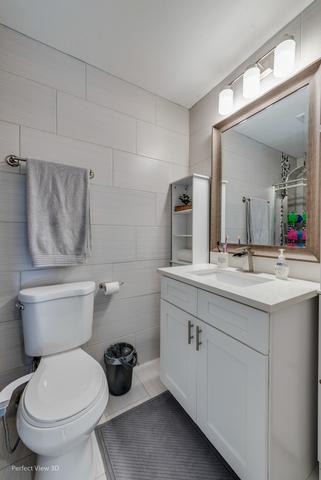 bathroom with a shower with curtain, vanity, and toilet