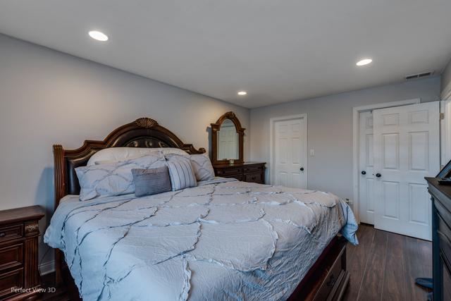 bedroom with dark hardwood / wood-style flooring and a closet