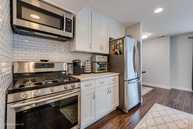 kitchen featuring white cabinets, dark hardwood / wood-style floors, appliances with stainless steel finishes, and tasteful backsplash