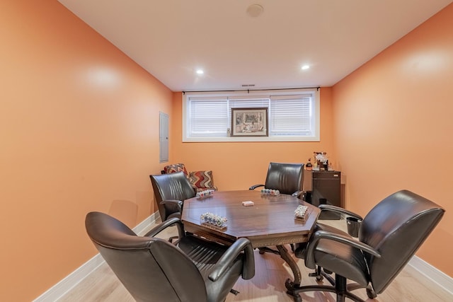 office space with electric panel and light hardwood / wood-style flooring