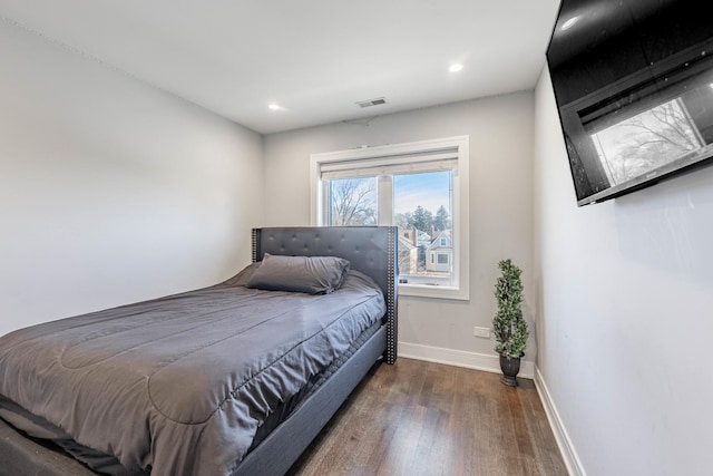 bedroom with dark hardwood / wood-style flooring